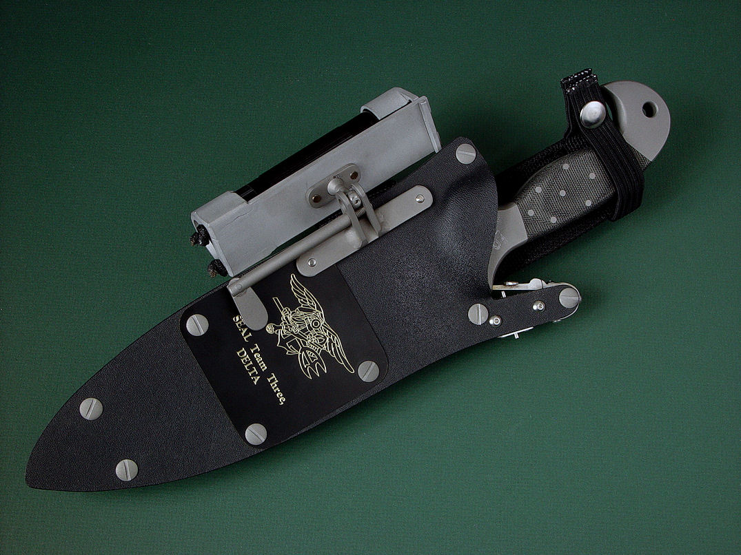 "Horus", with accessory view in ATS-34 high molydenum stainless steel blade, 304 stainless steel bolsters, engraved, Micarta phenolic handle, locking kydex, aluminum, stainless steel sheath with black lacquered brass engraved flashplate.