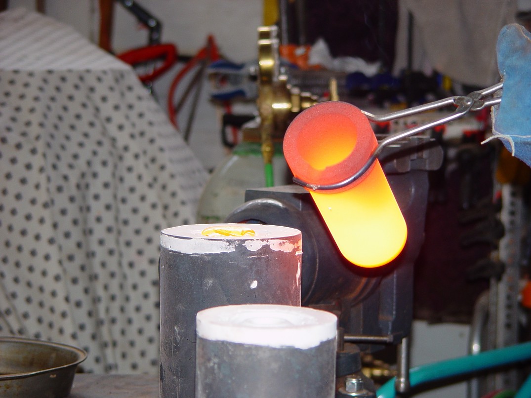 Pouring Molten silicon bronze into molds at 1975 degrees F for sword guard casting at Sharp Instinct Studio