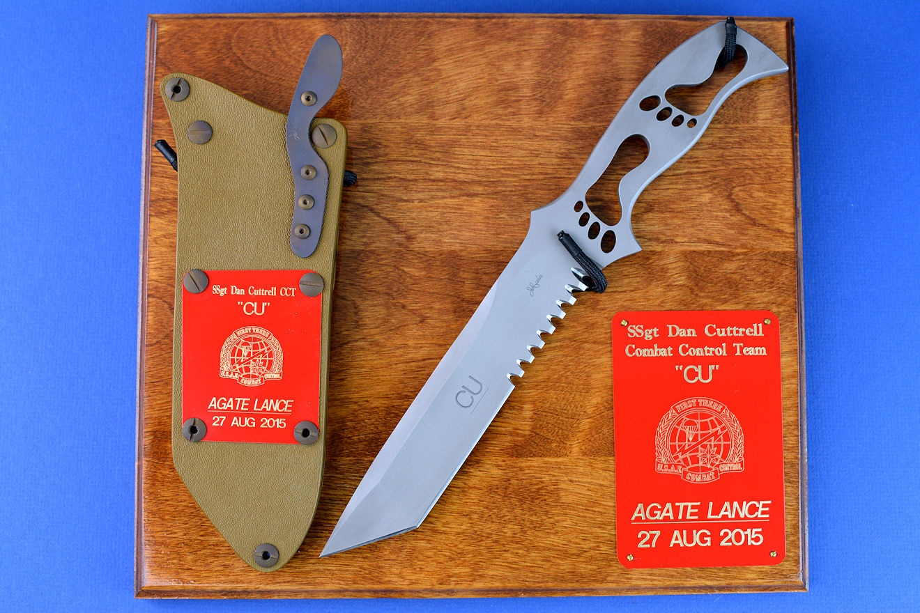 "PJSK" Custom Commemorative/Tactical Combat knife, obverse side, plaque view in 440c high chromium stainless steel blade, hybrid tension-locking sheath in kydex, anodized aluminum, titanium, stainless steel with plaque of ash and engraved laquered brass