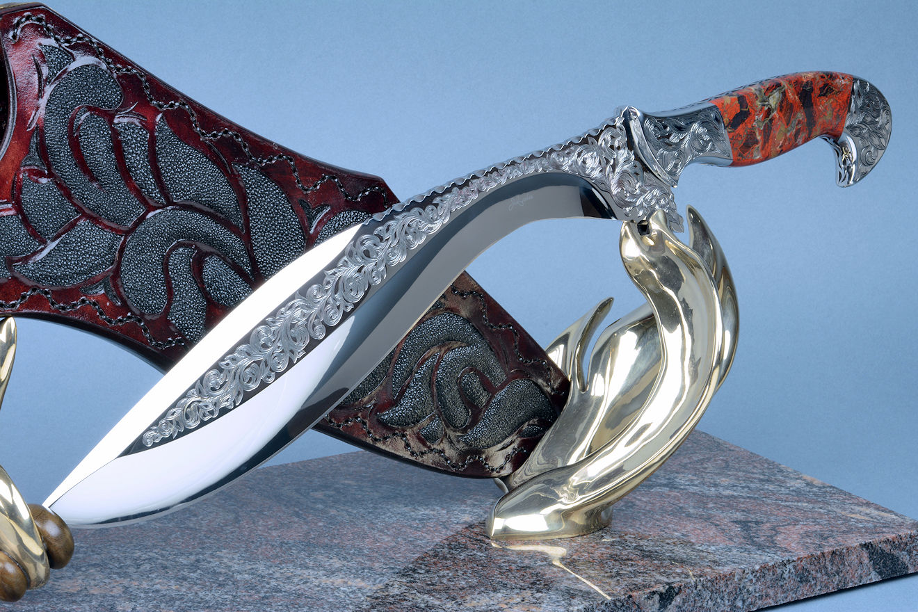 "Pallene" khukri, obverse side view in CPM154CM High molybdenum powder metal technology stainless tool steel blade, hand engraved, with hand-engraved 304 stainless steel bolsters, Brecciated Jasper gemstone  handle, hand-carved leather sheath inlaid with rayskin, hand-cast silicon bronze and Imbuya hardwood stand and Paradiso Classico Granite base