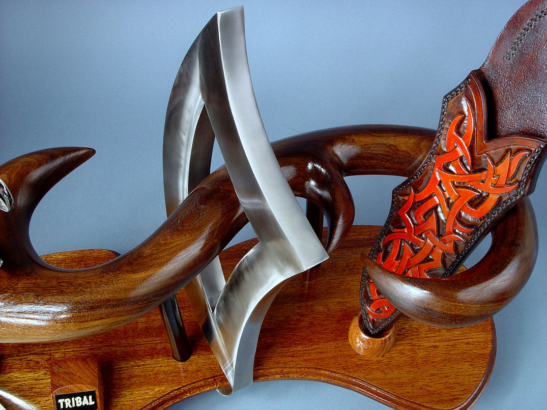 "Tribal" (Helhor patten) knife sculpture, stainless triangle center, flowing lines of hand-carved American black walnut hardwood