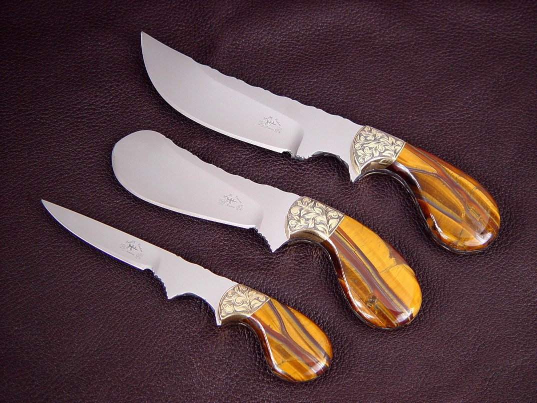 "Trophy Game Set" obverse side view in D2 extremely high carbon die steel blades, hand-engraved brass bolsters, Tiger Eye Gemstone handles: field dressing, skinning, caping knives