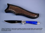 "Clarau" fine handmade knife, obverse side view: blued O-1 tool steel blade, hand-engraved 304 stainless steel bolsters, Lapis Lazulii gemstone handle, lizard skin inlaid in hand-carved leather sheath