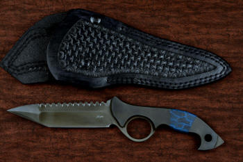 "Ari B'Lilah" counterterrorism, tactical, combat knife, obverse side view in T4 cryogenically treated 440C high chromium martensitic stainless steel blade, 304 stainless steel bolsters, blue/black tortoiseshell G10, black micarta  handle, post-lock leather sheath in 9-10 oz. shoulder, double row nylon stitching, black oxide stainless steel snaps and reinforcement hardware