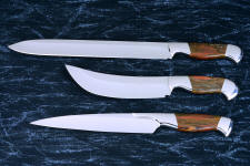 "Bordeaux, Courbe Vaste, Thresher" fine handmade chef's knives, BBQ knives, obverse side view in T3 cyrogenically treated 440C high chromium stainless steel blades, 304 stainless steel bolsters, Caprock petrified wood gemstone handles, Bison (American Buffalo), leather shoulder book case
