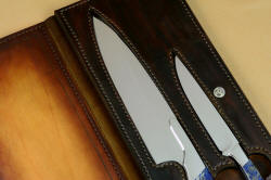 Blades in pockets in hand carved leather shoulder in book case of Concordia and Sanchez Custom Chef's Knives in T3 cryogenically treated 440C high chromium stainless steel blades, 304 stainless steel bolsters, Lapis Lazuli gemstone handles, book case in top grain leather, leather shoulder and belly, hand-carved, stainless steel snaps