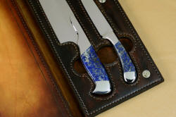 Finger holes and knife positions inside book case leather of Concordia and Sanchez Custom Chef's Knives in T3 cryogenically treated 440C high chromium stainless steel blades, 304 stainless steel bolsters, Lapis Lazuli gemstone handles, book case in top grain leather, leather shoulder and belly, hand-carved, stainless steel snaps
