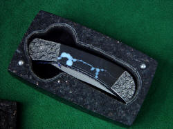 "Gemini" folding knife detail in black granite case. Sarcophagus case protects investment grade folding knife with elegance and permanance