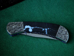 "Gemini" linerlock folding knife, folded. Blue sapphire gemstone set studs allow opening with thumbnail.