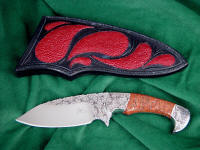 "Ocate" fine handmade custom skinning, field dressing knife, obverse side view in engraved 440C high chromium stainless steel blade, 304 stainless steel bolsters, copper ore gemstone handle, red Stingray skin inlaid in hand-carved leather sheath