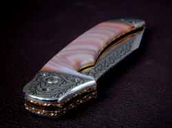 "Procyon" is a large folding knife, one of the largest possible. Front bolster detail shows fully hand-fileworked anodized titanium liners and lock plate