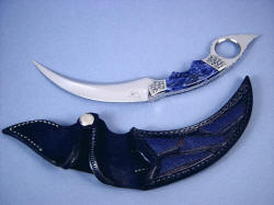 "Raptor" kerambit (Tunguska) obverse side view in mirror polished 440C high chromium stainless tool steel blade, hand-engraved 304 stainless steel bolsters, Sodalite gemstone handle, blue stingray skin inlaid in hand-carved leather sheath