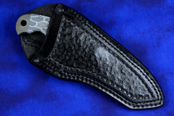 "Skeg"  tactical, counterterrorism, crossover knife, sheathed view in T4 Cryogenically treated ATS-34 high molybdenum martensitic stainless steel blade, 304 stainless steel bolsters, white and black tortoiseshell pattern G10 fiberglass/epoxy composite handle, sheath in 9-10 oz. leather shoulder, hand tooled, stitched with nylon, stainless steel fasteners