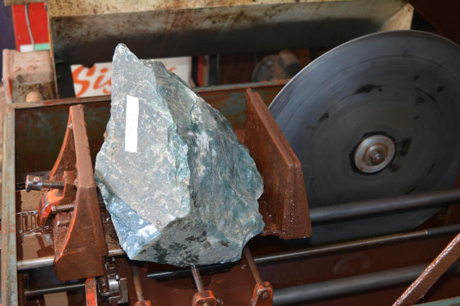 Gemstone clamped in saw vise in large blocking, slabbing saw