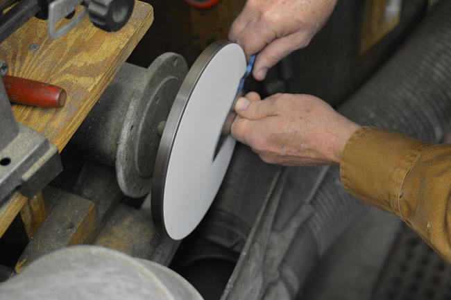 Disk grinding a knife blade flat